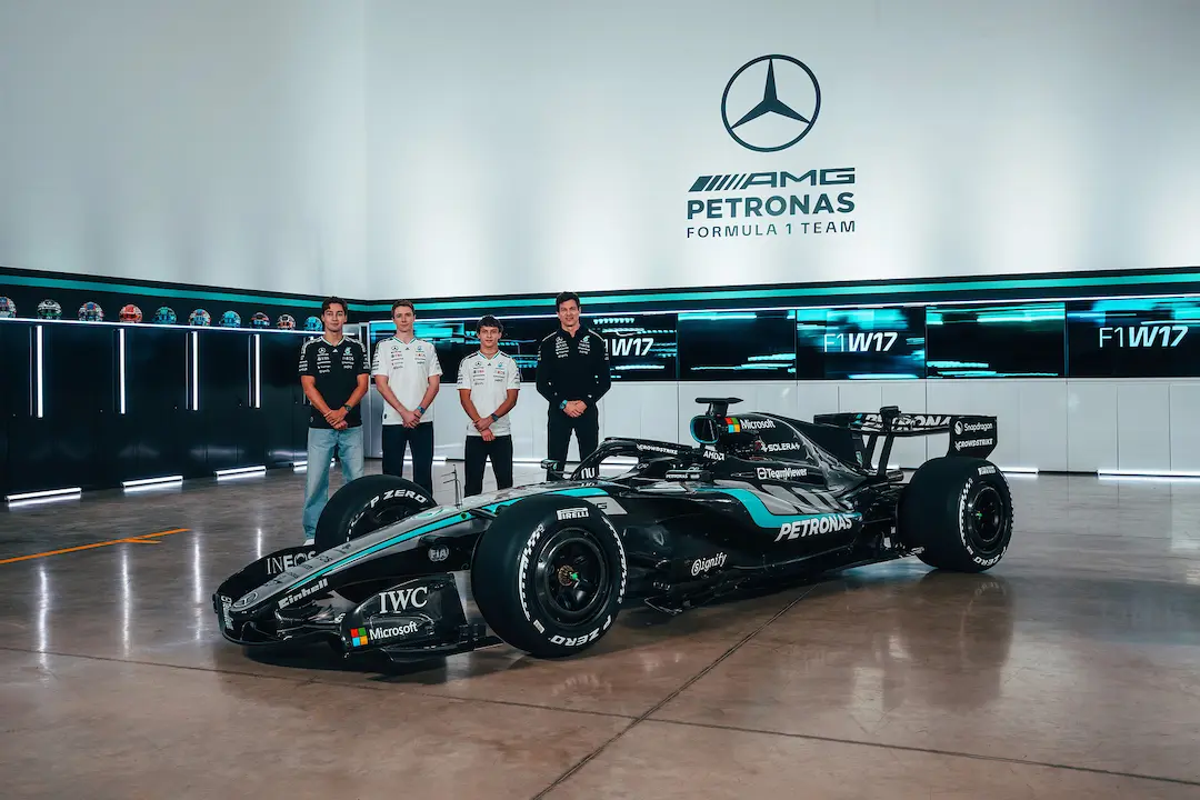 Mercedes W17 2026 Formula 1 car on display with George Russell, Kimi Antonelli, Fred Vesti, and Toto Wolff at the Brackley factory during the 2026 car presentation, showing the new silver and teal livery and 2026 technical regulations. © Mercedes-AMG PETRONAS F1 Team Media