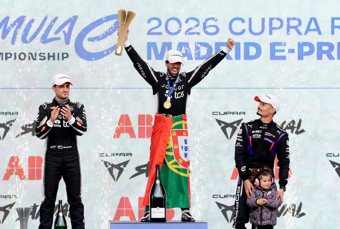 António Félix da Costa celebrates on the podium after winning the 2026 Madrid E-Prix Race Report event at Circuito del Madrid Jarama, holding the winner’s trophy with Mitch Evans and Pascal Wehrlein alongside © Formula E Media