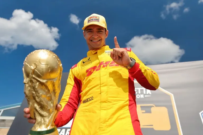 Alex Palou holds a replica World Cup trophy and raises one finger after winning the Music City Grand Prix 2026 at Nashville Superspeedway, celebrating on the same weekend as Spain’s World Cup triumph. © Penske Entertainment / Chris Owens