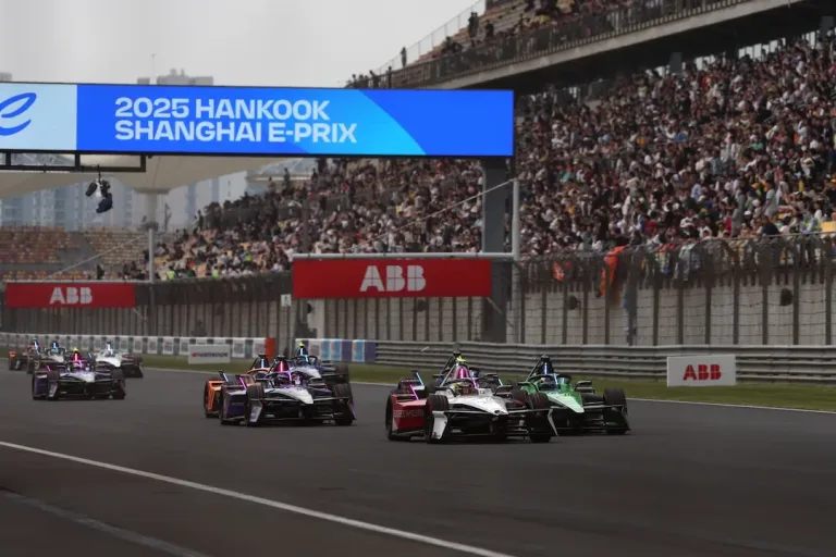 Shanghai E-Prix 2026 Preview image showing Formula E cars racing at Shanghai International Circuit in front of packed grandstands and event signage.