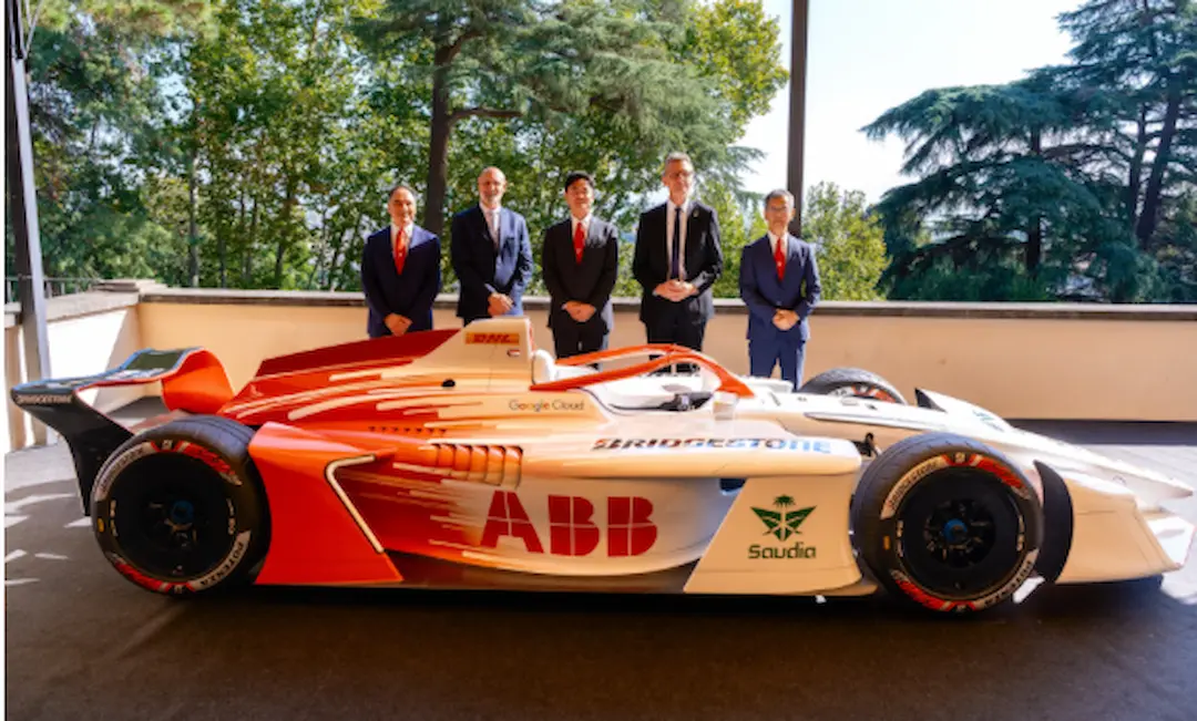 Bridgestone Formula E launch in Rome, with the white and orange GEN4 show car on Bridgestone tyres in the foreground and five officials in suits standing behind it on an outdoor terrace ©Formula E